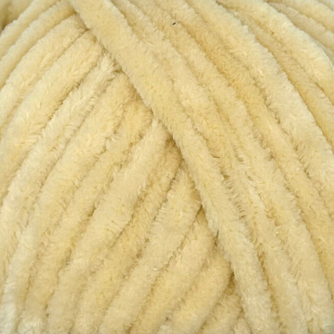 A close-up of thick, fluffy chenille yarn in a soft cream or pale yellow color, showing the textured loops of the material.
