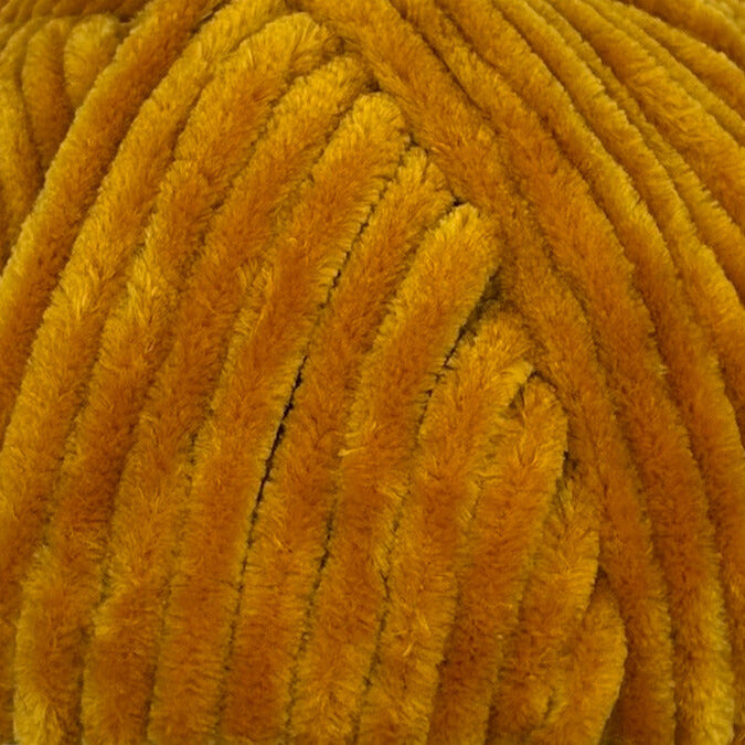 A close-up of thick, plush chenille yarn in a warm mustard yellow color, showing the fuzzy texture of the strands.