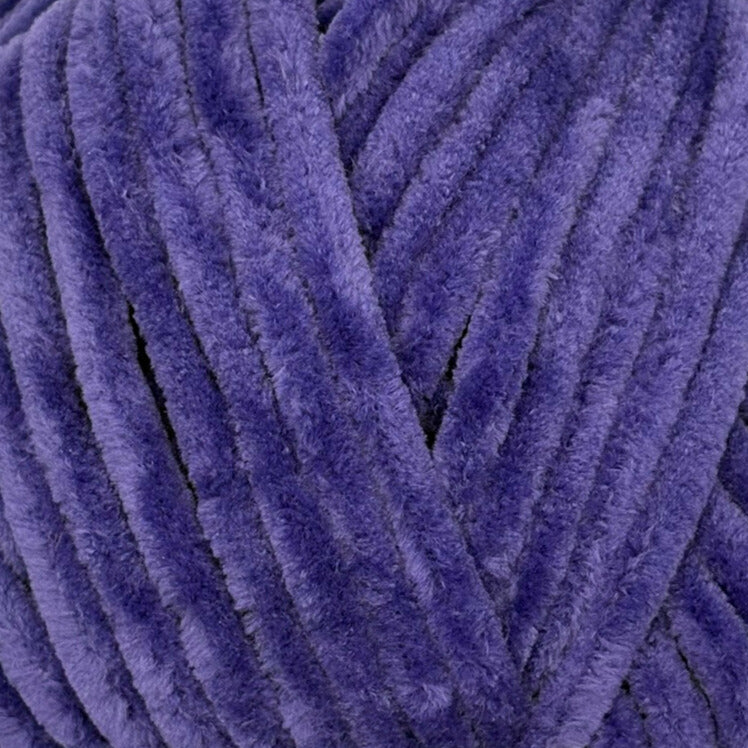 A close-up of plush, fuzzy yarn strands in a rich purple color, filling the entire frame.