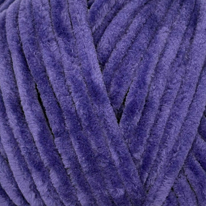 A close-up of plush, fuzzy yarn strands in a rich purple color, filling the entire frame.