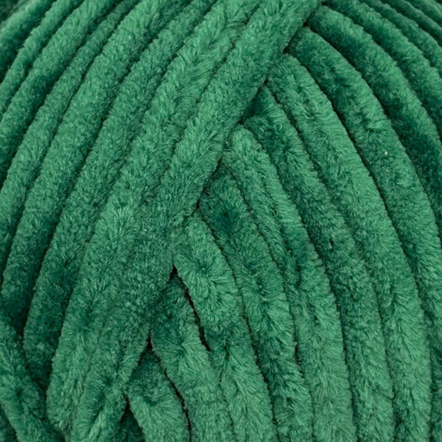 A close-up of a textured green plush or fuzzy fabric surface with repeating vertical ridges.