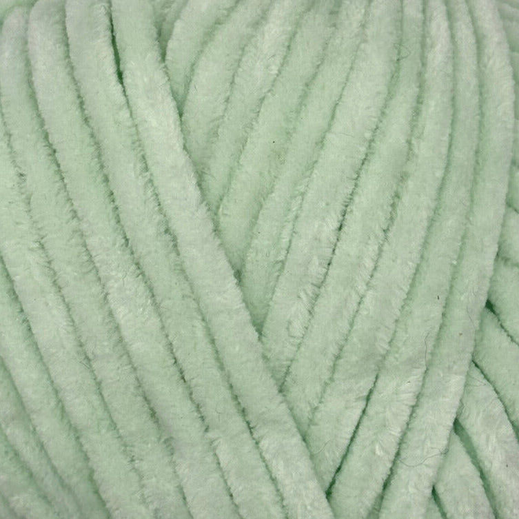 A close-up of mint green fuzzy chenille yarn strands, showing the soft plush texture and thick cord-like thickness.