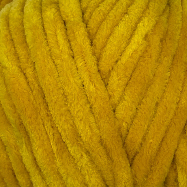 A close-up of thick, fuzzy mustard yellow yarn strands filling the frame.