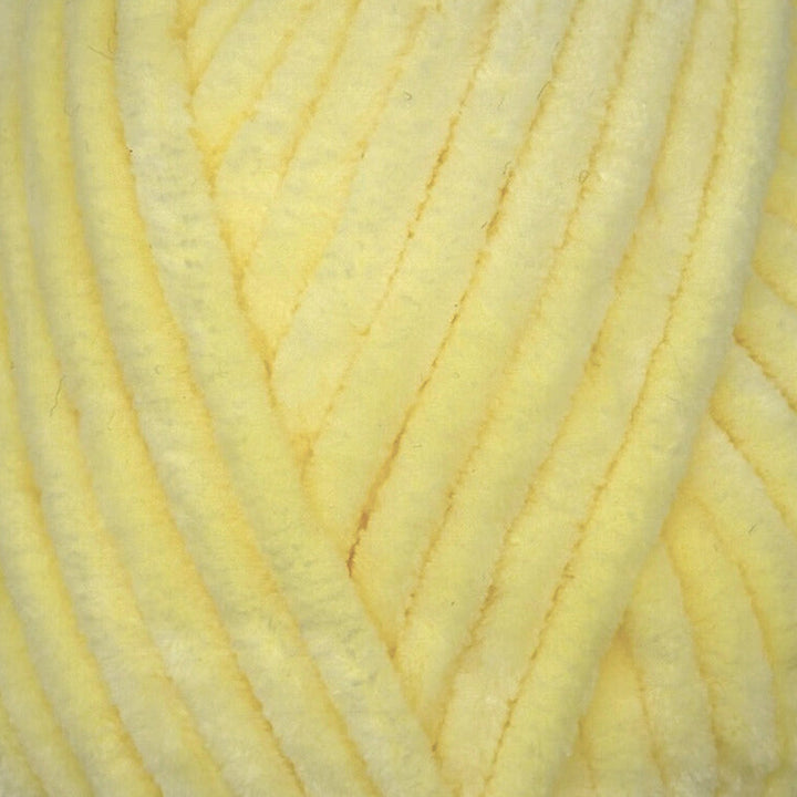 A close-up of pale yellow fuzzy yarn strands filling the frame.