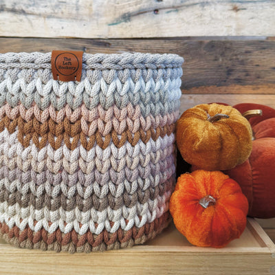 Knitted basket with a wooden background and pumpkins
