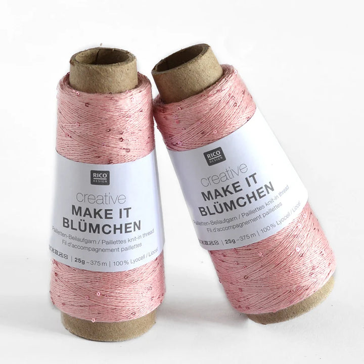 Two spools of Rico Design Creative Make It Bümchen thread in a dusty pink color with small sequins, standing on a white background.