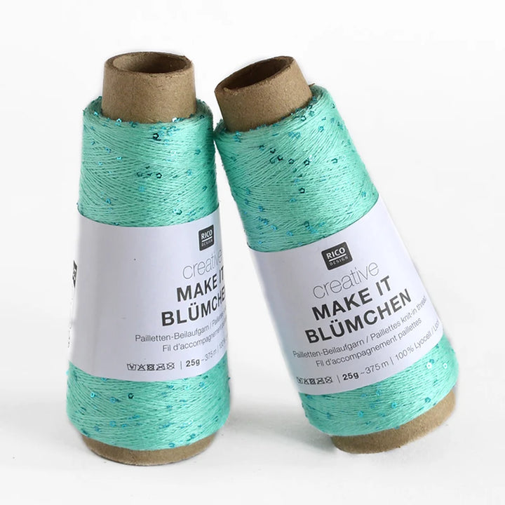 Two spools of Creative Make It Blümchen thread in a light mint green color with subtle sequins, standing on a white background.