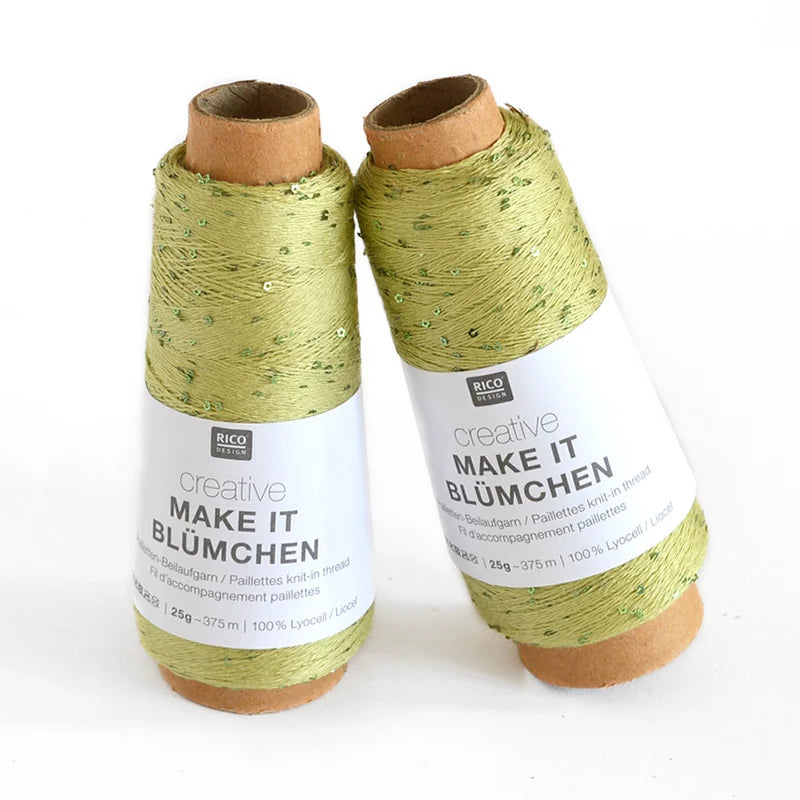 Two cones of Rico Design Creative Make It Blümchen thread in a light olive green color with subtle sequins, displayed on a clean white background.