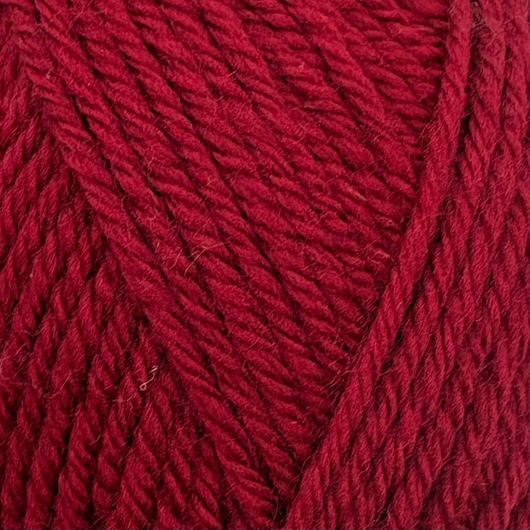 A close-up of textured yarn in a rich dark red or burgundy color, showing the twisted plies and soft fibers.