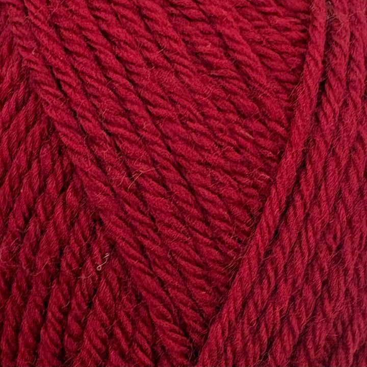 A close-up of textured yarn in a rich dark red or burgundy color, showing the twisted plies and soft fibers.