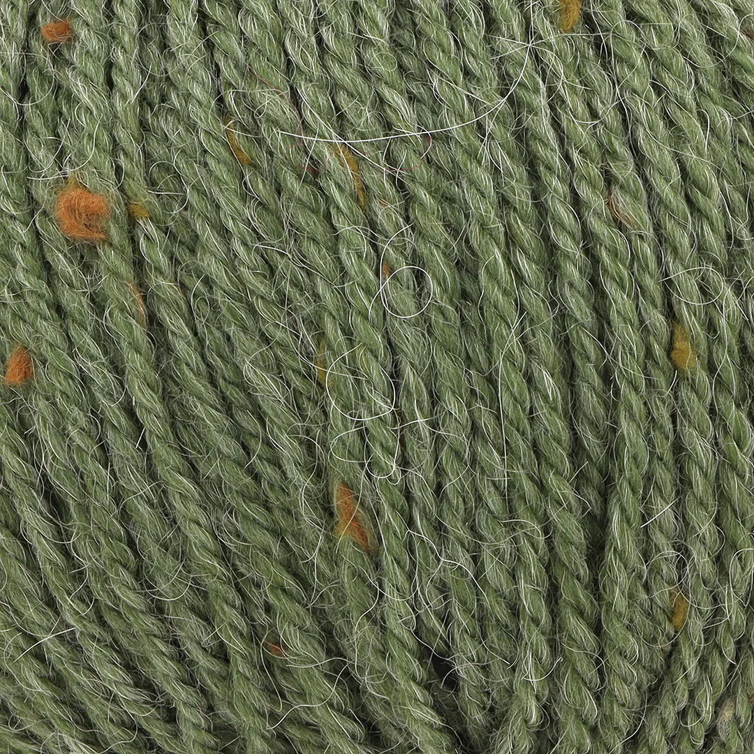 Close-up of green yarn with small orange specks