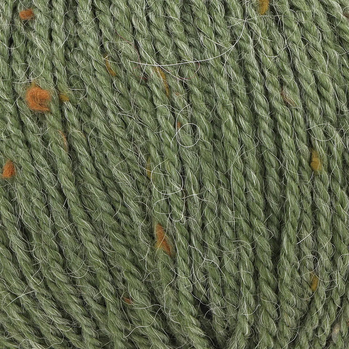 Close-up of green yarn with small orange specks