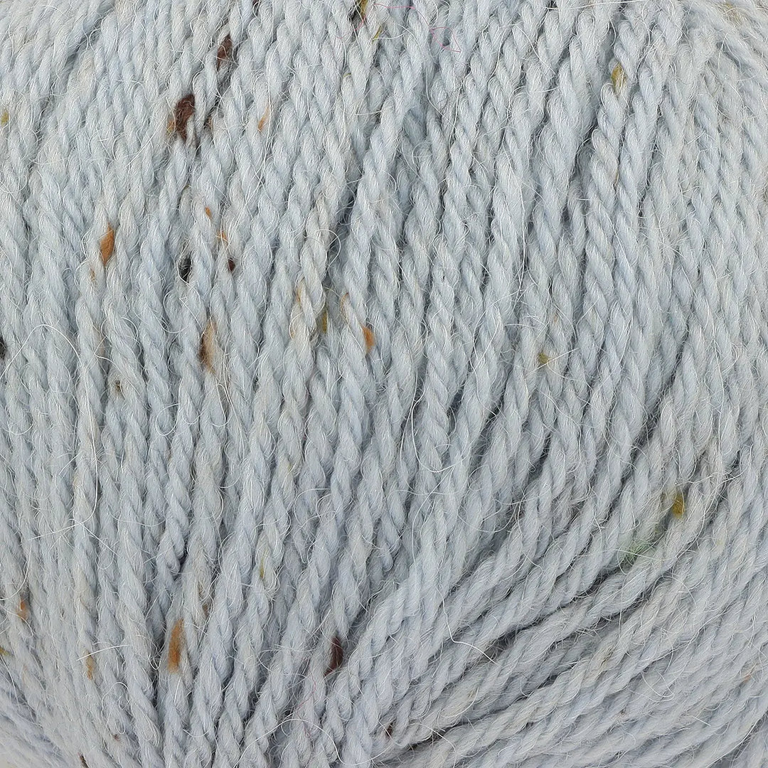 Close-up of gray yarn with specks of brown and black.