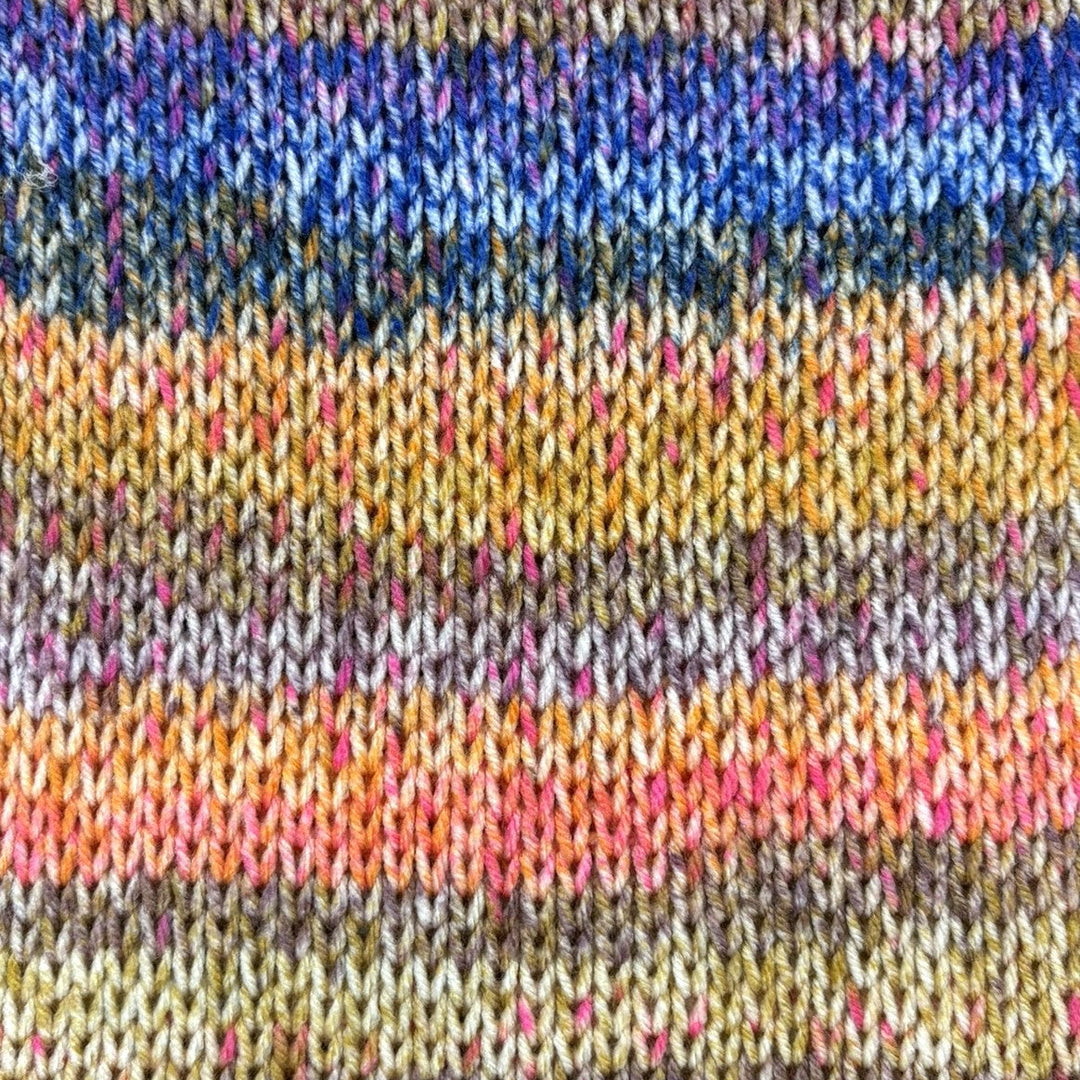 Close up of a multi coloured striped knitted fabric with blues, yellows, reds and greens