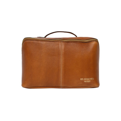Brown leather toiletry bag with 'RE DESIGNED' label on a white background