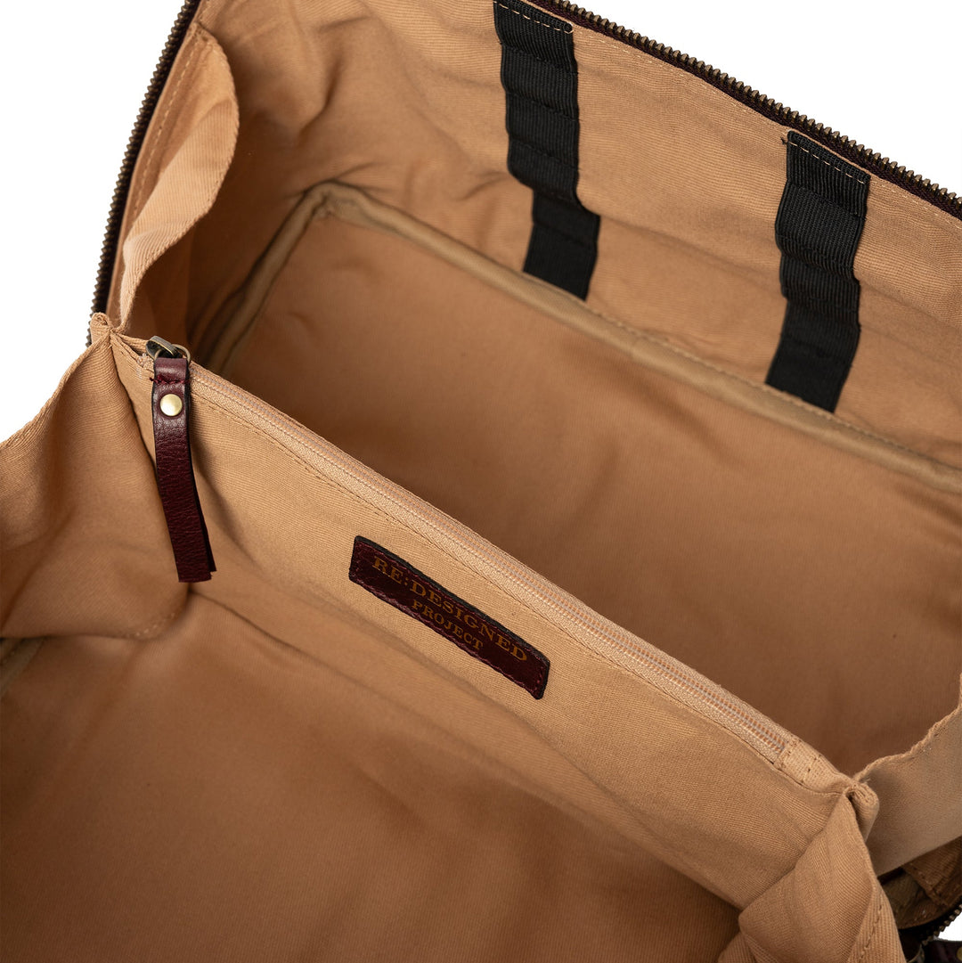 Open dark cherry leather bag with visible brand label on a white background