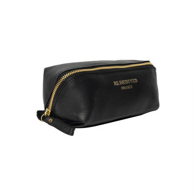 Black leather toiletry bag with gold zipper on a white background