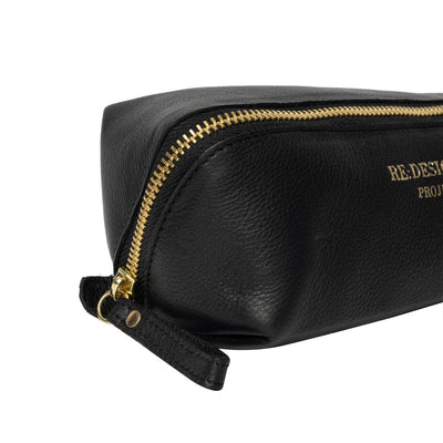 Black leather pouch with gold zipper on a white background