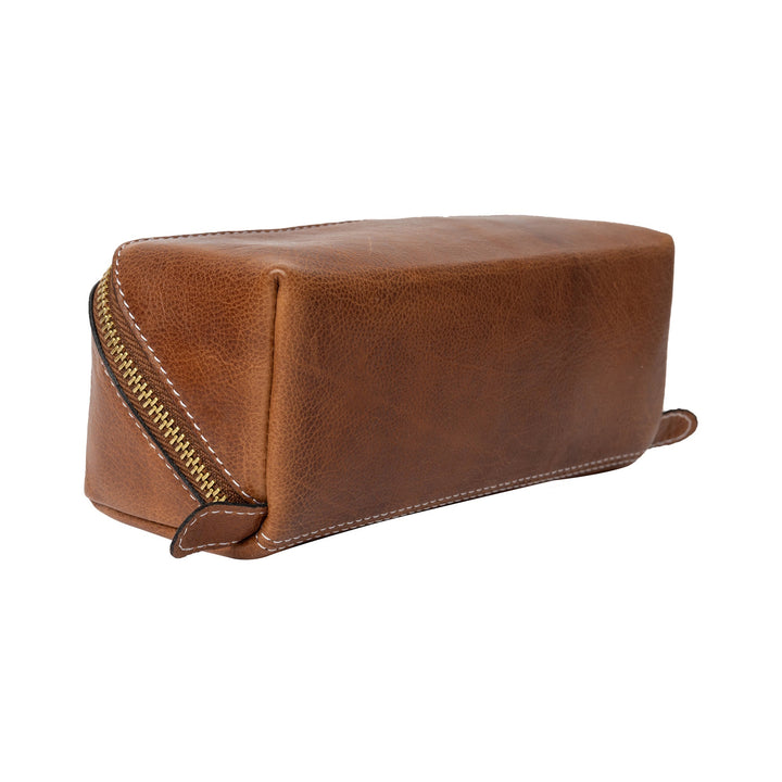 Brown leather toiletry bag with a zipper on a white background