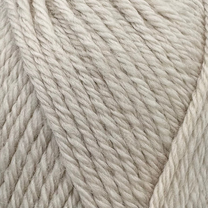 A close-up of cream-colored twisted yarn strands, showing the texture and color of the fiber.