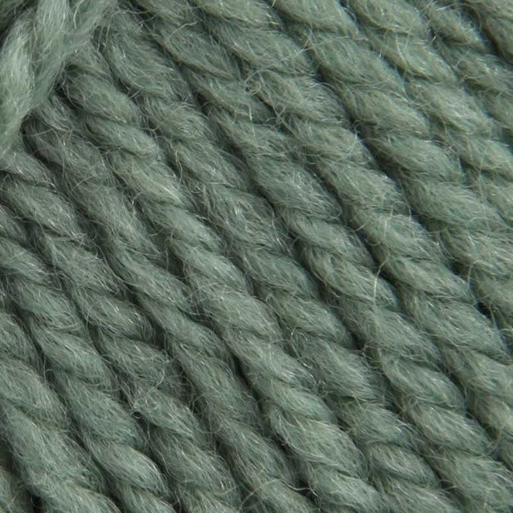 A close-up texture shot of twisted yarn in a muted sage green color, showing the fuzzy, soft fibers in detail.