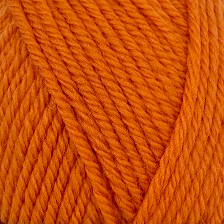 A close-up of bright orange yarn strands wound together, showing the texture and color of the fiber.