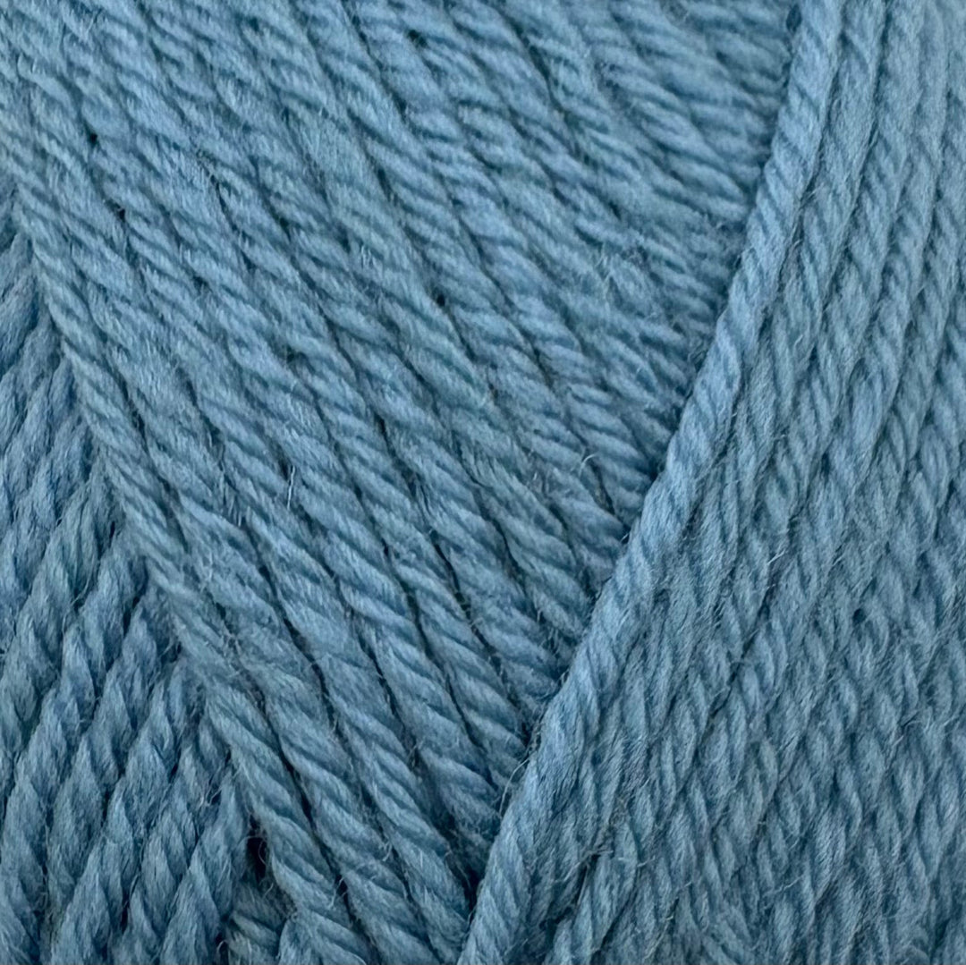 A close-up of textured yarn in a soft blue colour, showing the twisted plies and soft fibers.