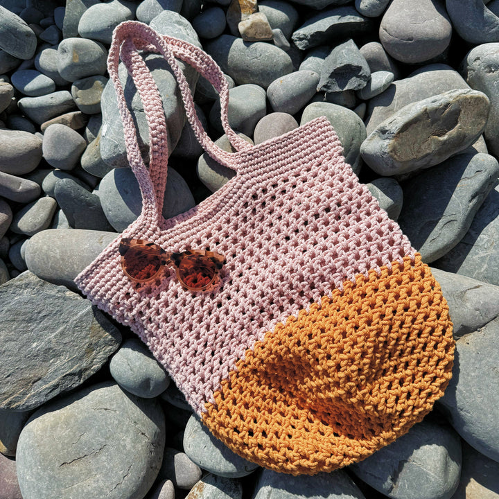crochet beach bag on pebbles
