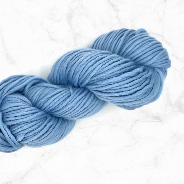 skein of blue super chunky yarn on a marble background