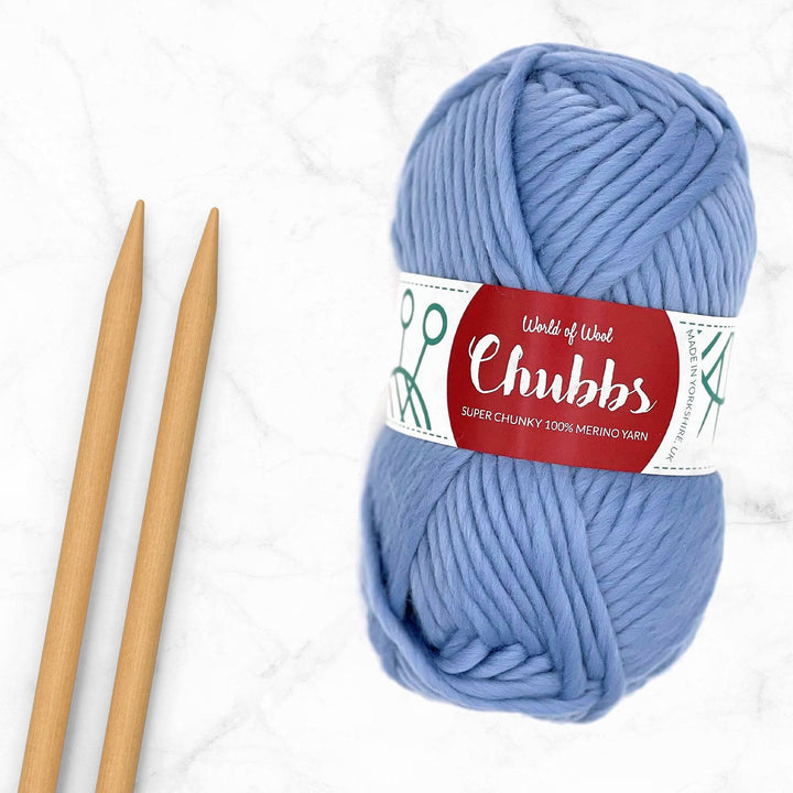 blue super chunky yarn on next to some bamboo knitting needles