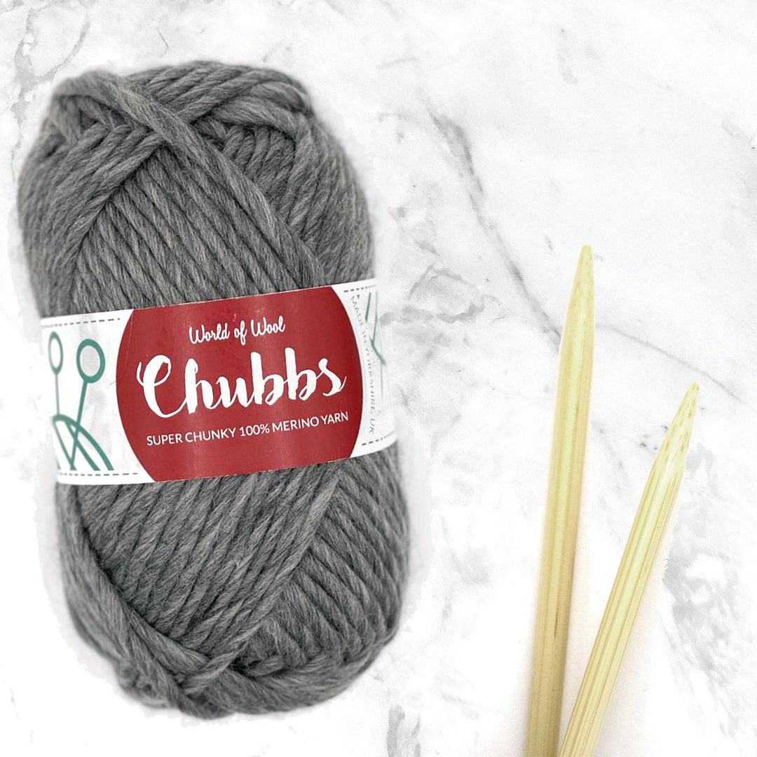 soft grey yarn ball next to some bamboo knitting needles