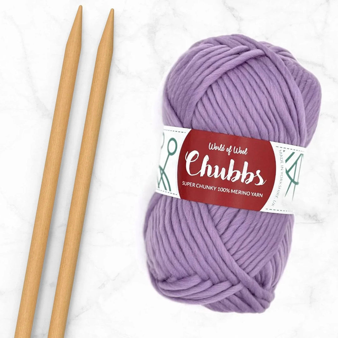 lavender yarn ball next to a pair of bamboo needles