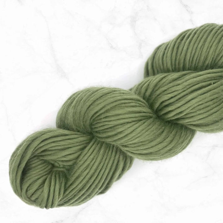 skein of olive coloured yarn on a marble background