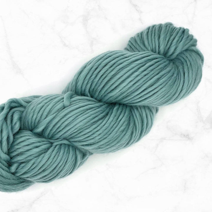 teal yarn skein on a marble background