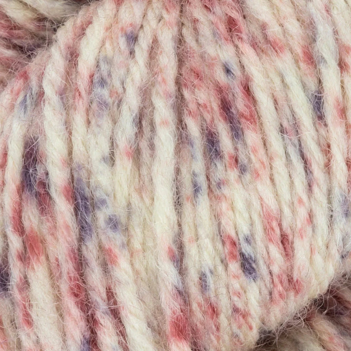 Close-up of a skein of multicolored yarn with red, purple, and beige tones.