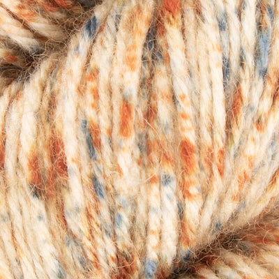 Close-up of a skein of yarn with speckled orange and blue